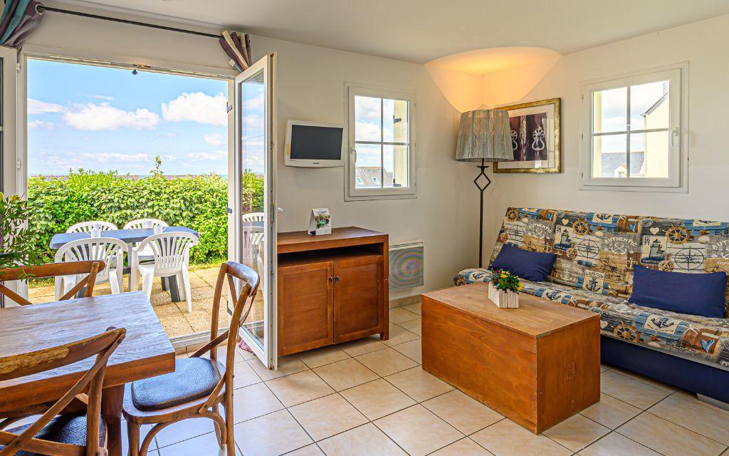 Slide Séjour avec espace salon et fenêtre ouverte sur l’océan aux terrasses de Pentrez