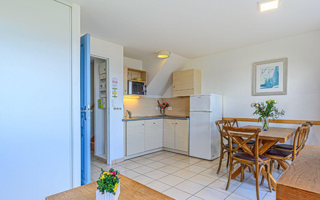 Slide Cuisine équipée ouverte sur le salon d’une maisonnette aux Terrasses de Pentrez