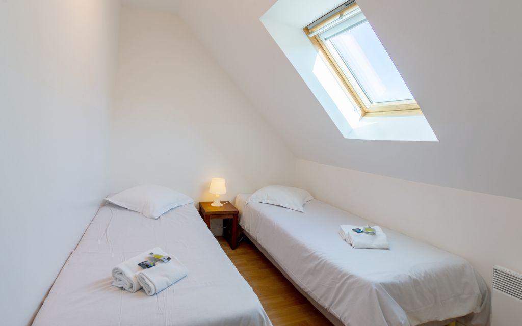 Slide Chambre avec deux lits simples et une table de chevet dans une maison des terrasses de Pentrez