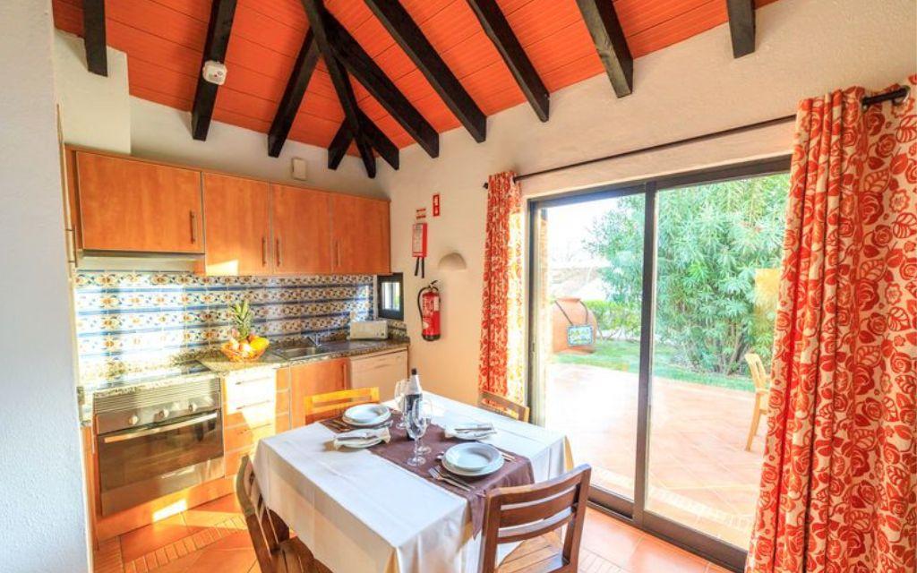 Slide Open-plan kitchen leading onto the dining area with direct access to the outside of the villa at Pedras del Rei