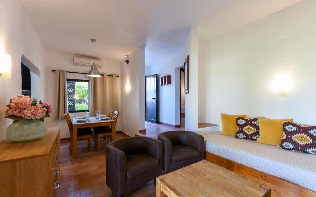 Slide Espace salon avec canapé et fauteuils et salle à manger en arrière-plan dans une villa de Pedras da Rainha au Portugal