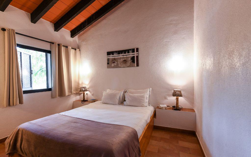 Slide Chambre avec un lit double et tables de chevet dans une villa de Pedras da Rainha