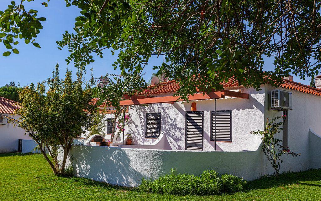 Slide Exterior of a detached villa surrounded by greenery within the Pedras da Rainha residence in Portugal