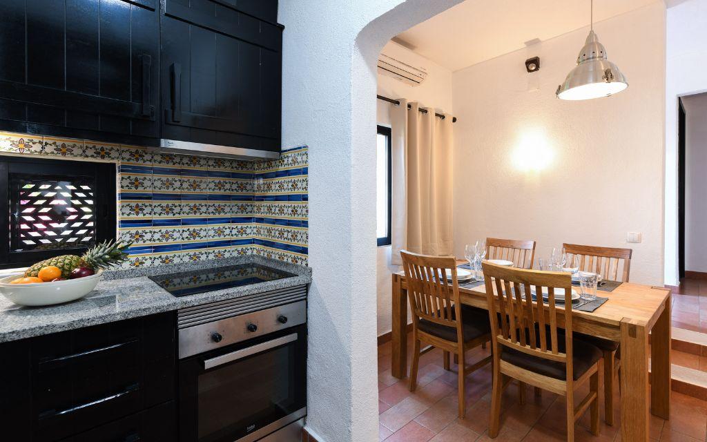 Slide Fully equipped kitchen open to the dining room within accommodation at the Pedras da Rainha resort