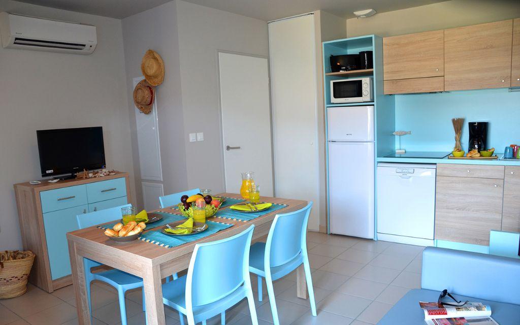 Slide Séjour avec espace salle à manger et cuisine ouverte dans une maisonnette de la résidence La Grenadine