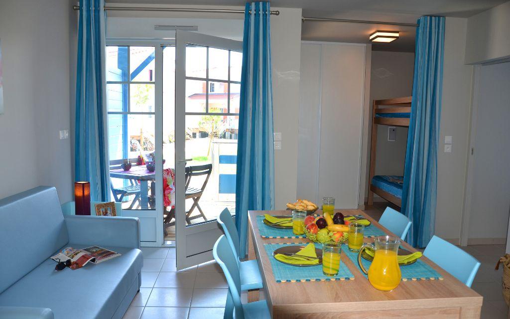 Slide Living space with dining table opening onto a glass door and a private terrace within an accommodation at La Grenadine residence