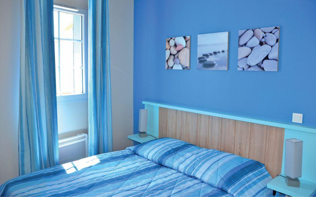 Slide Bedroom with a double bed and two bedside tables in a holiday cottage at La Grenadine residence in Marseillan-Plage