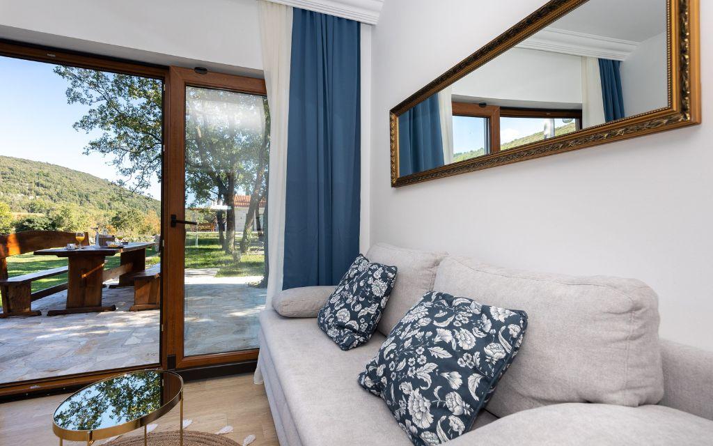 Slide Salon des Maisonnettes Sveta Ana Lodges ouvert sur une grande terrasse en bois et à l'abris du soleil