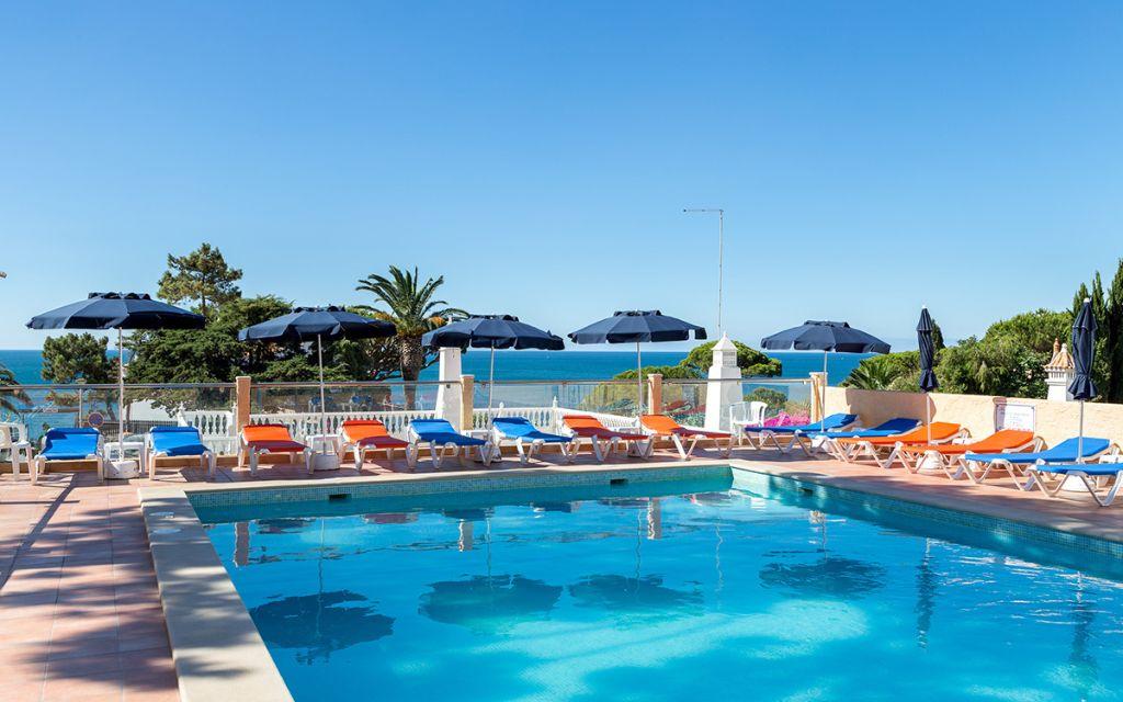 Slide Piscine avec chaises longues et transats en bord de mer à la résidence Do Parque à Olhos d'Agua