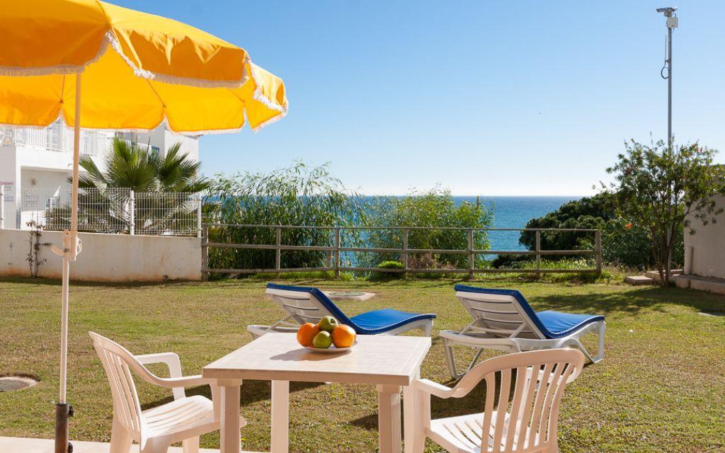 Slide Terrace with outdoor furniture on the ground floor of the Do Parque residence in Olhos d’Água