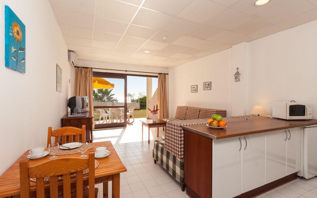 Slide Interior of a ground-floor apartment at the Do Parque residence, with a living area opening onto the terrace