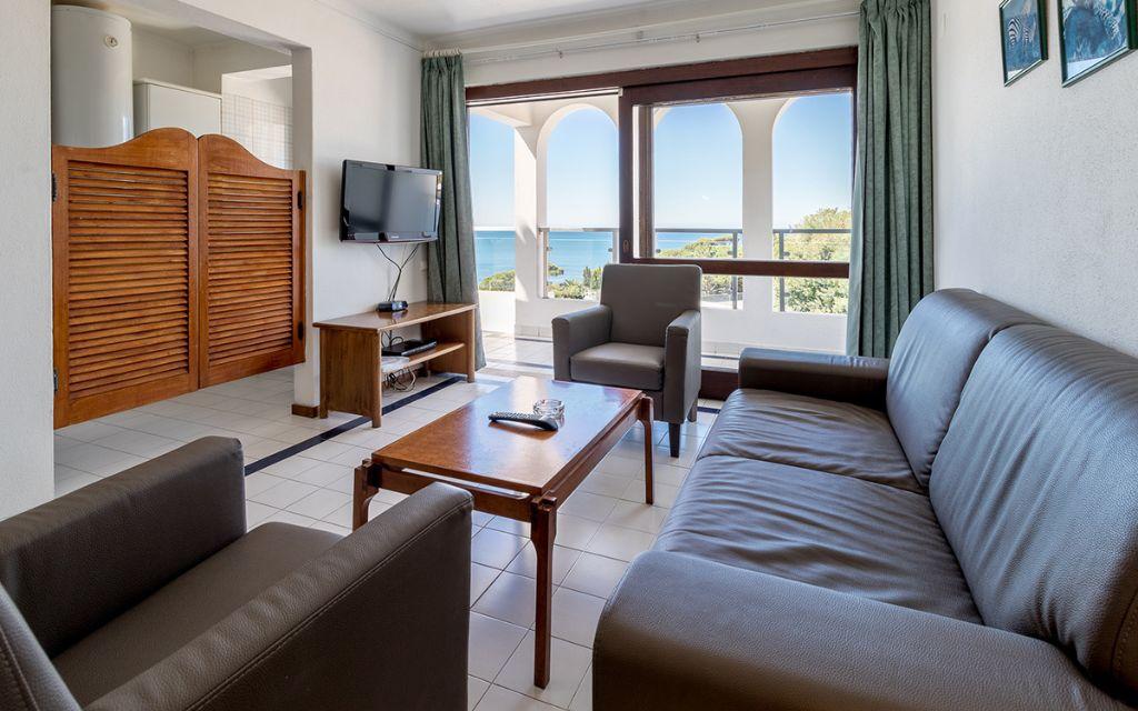Slide Bright living room opening onto a balcony in the superior apartments of the Do Parque residence in Olhos d’Água