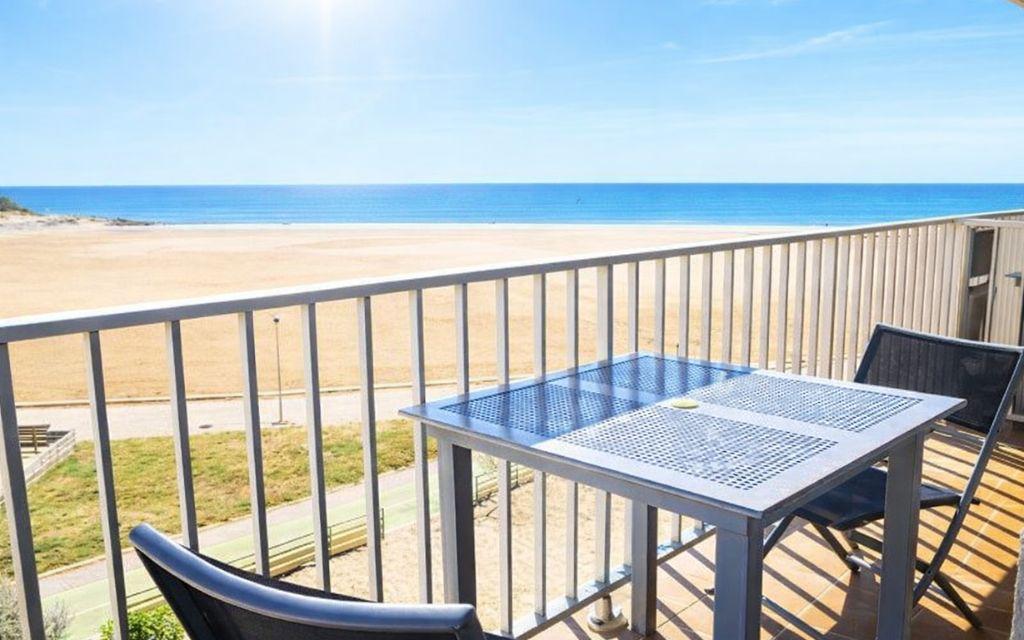 Slide Balcony of a studio apartment with outdoor furniture and sea view at the Neptune residence.