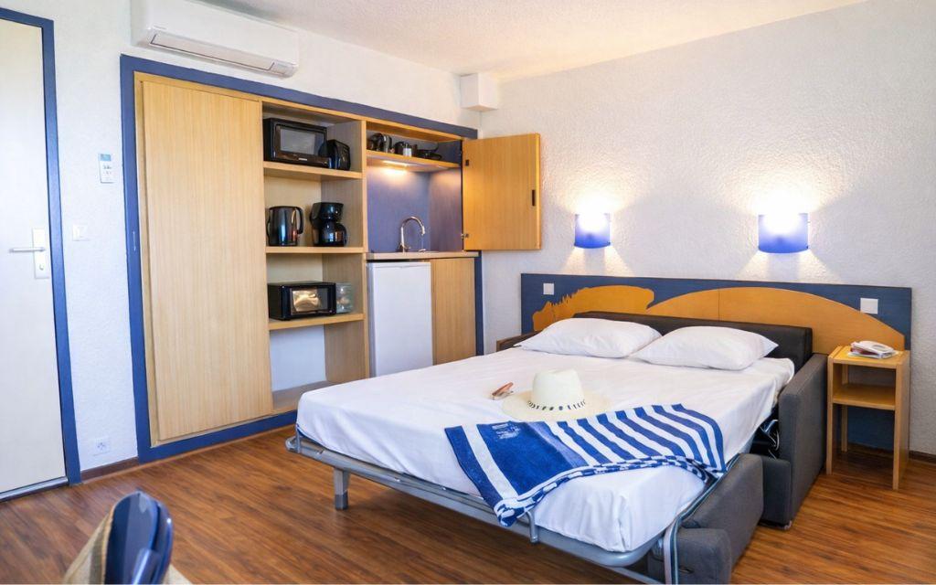 Slide Interior of a studio apartment in the Neptune residence with kitchenette and sofa bed.