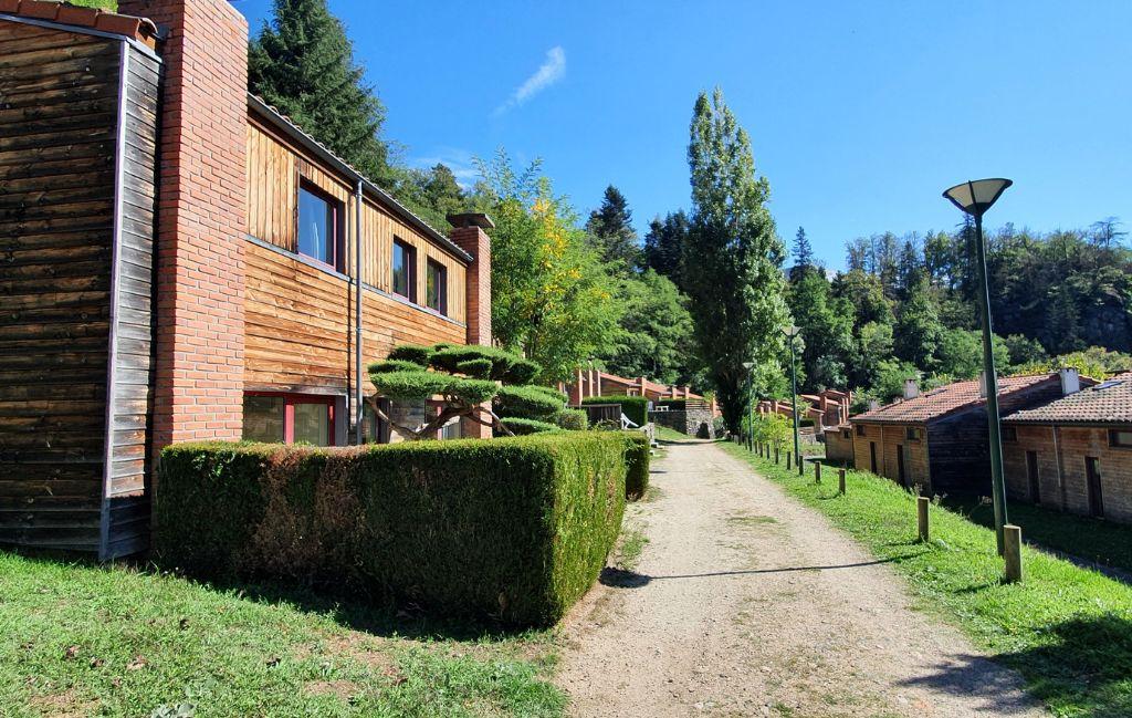 Slide Shared area of Résidence Vorey-sur-Arzon with red-brick cottages and pedestrian pathway