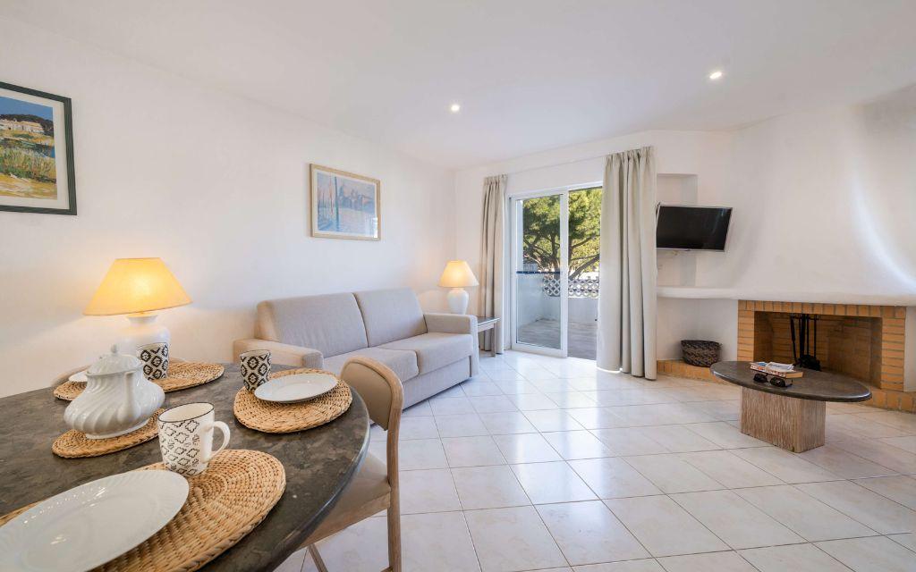 Slide Espace salon avec coin repas canapé et ouverture sur un extérieur privatif dans les logements supérieurs du Balaia Golf Village