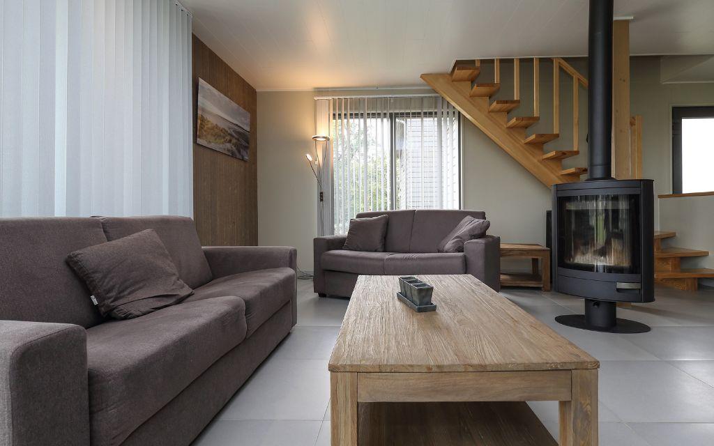 Slide Relaxation area with a lounge equipped with a wood-burning stove for optimal comfort at Golden Lakes Village Estate