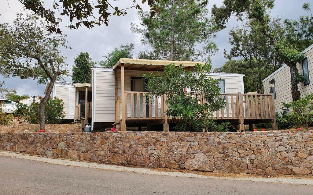Slide Bermudes mobile home with shaded outdoor terrace at Camping Lacasa in Calcatoggio