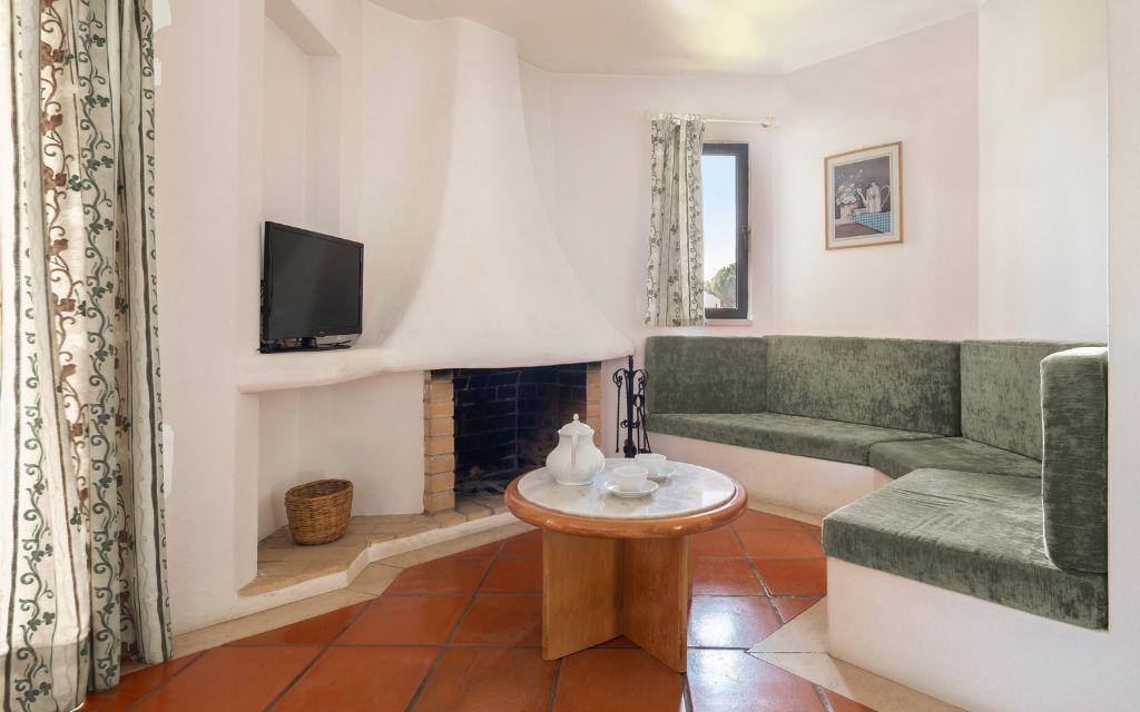 Slide Living area with sofa, fireplace, and television in the standard accommodations at Balaia Golf Village