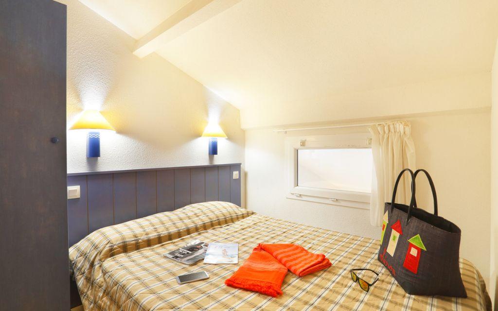 Slide Bedroom with one double bed and two wall-mounted bedside lamps.