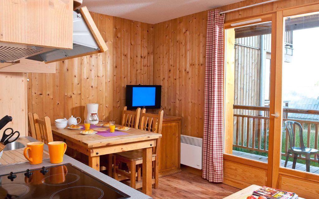 Slide Les Chalets du Berger sejour avec salon et petite cuisine ouverte equipee et tv