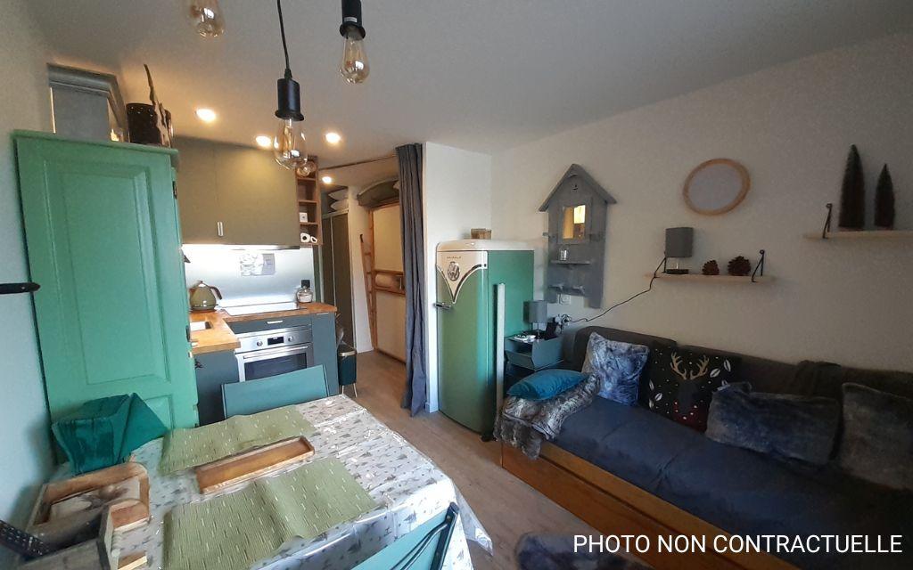 Slide Open-plan living room and kitchen with a pull-out sofa bed in the Valfréjus studios