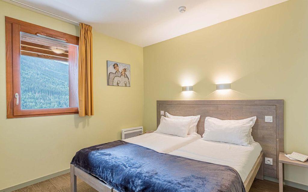 Slide Chambre principale avec un lit double ou deux lits simples dans les appartements de la résidence Les Epinettes à Vaujany