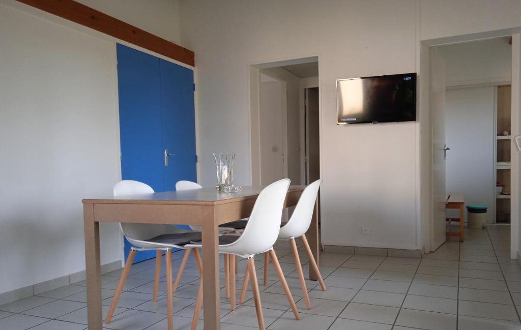 Slide Sejour avec table a manger et television au sein d'une maison du domaine de lambon