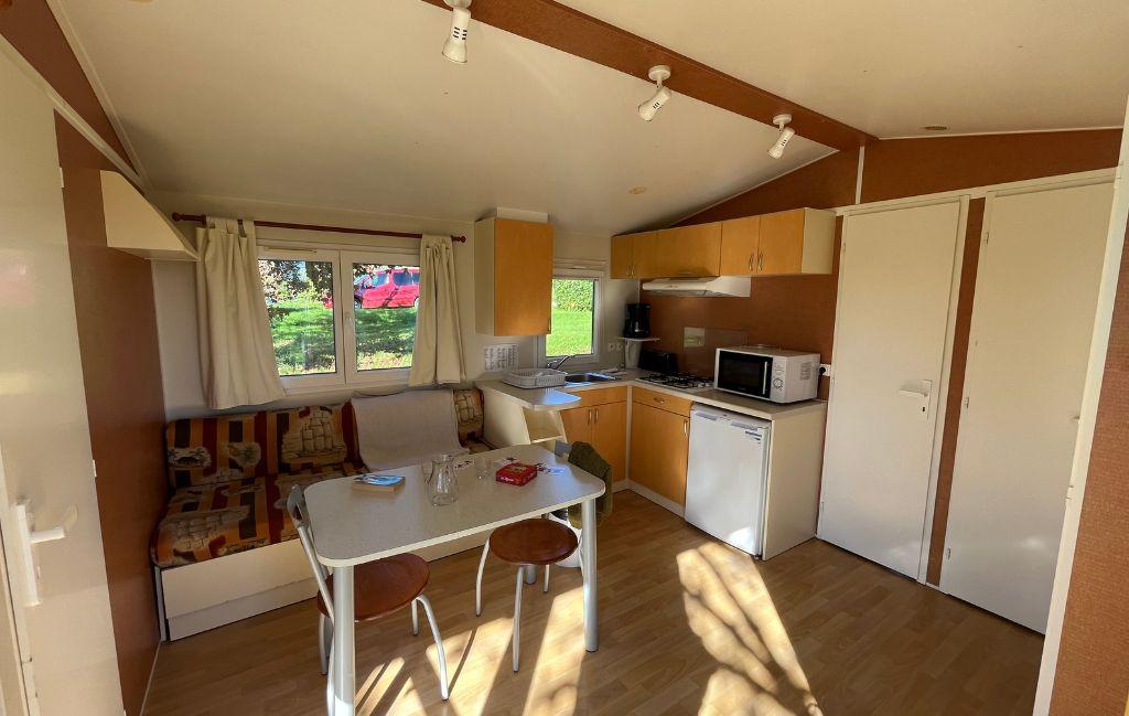 Slide Interieur d'un mobil home avec coin salon et cuisine au domaine de lambon
