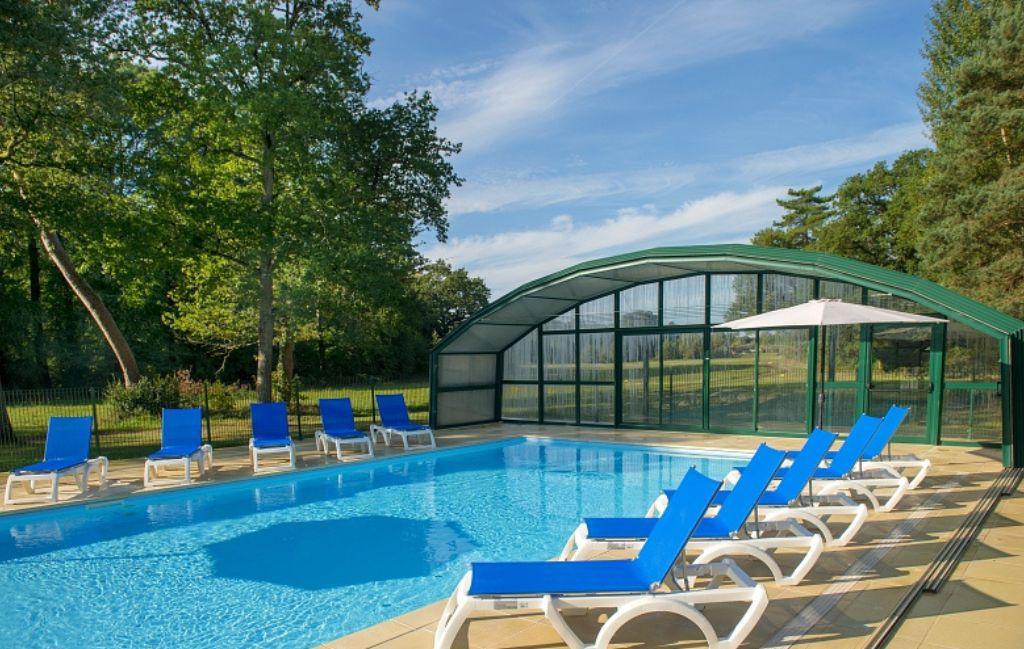 Slide Heated indoor swimming pool with sun loungers at Village Club La Ferté-Imbault