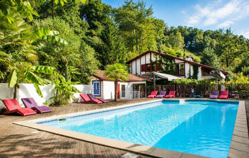 Slide Piscine avec transats colorés au bord de la piscine de la résidence Les Collines Iduki