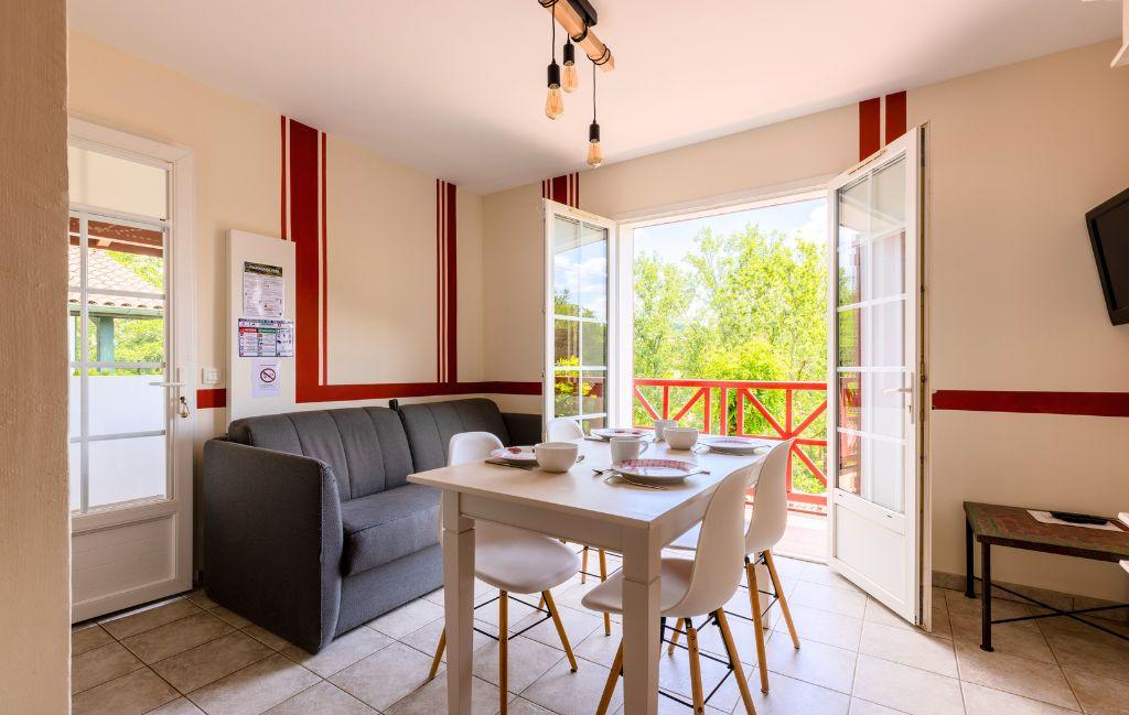Slide Séjour d’un appartement pour 4 personnes avec canapé et table à manger aux Collines Iduki