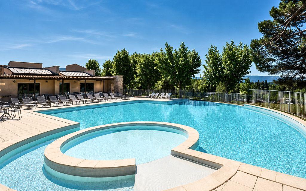 Slide Large outdoor swimming pool with paddling area at the Provence Country Club residence.