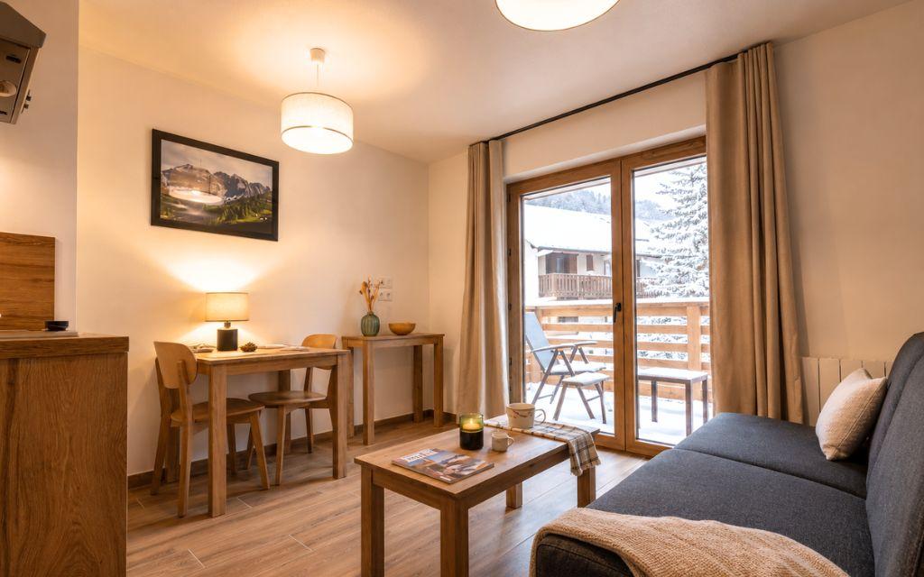Slide Living room with sofa and table in a studio apartment at the Arya Living Stone residence