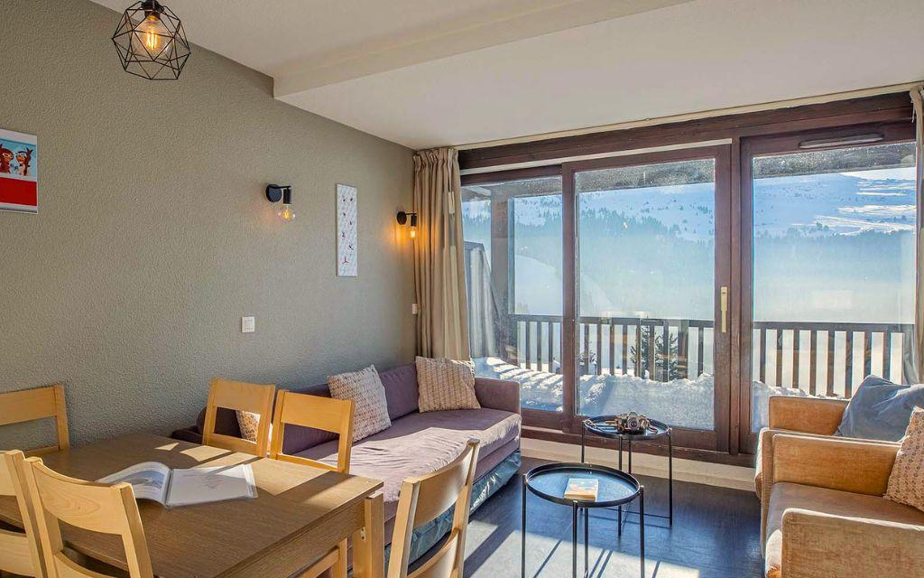 Slide Salon avec fauteuil lit et coin repas dans les appartements Les Terrasses de Veret à Flaine