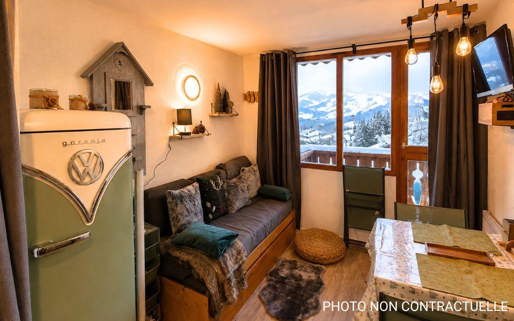 Slide Open-plan living room and kitchen with a pull-out sofa bed in the Valfréjus studios