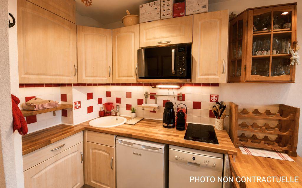 Slide Fully equipped kitchen with modern appliances and mountain-style décor in the Valfréjus studios.
