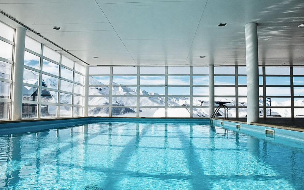 Slide Piscine intérieure de la résidence les Adrets de Peyragudes avec une vue direct sur les montagnes enneigées