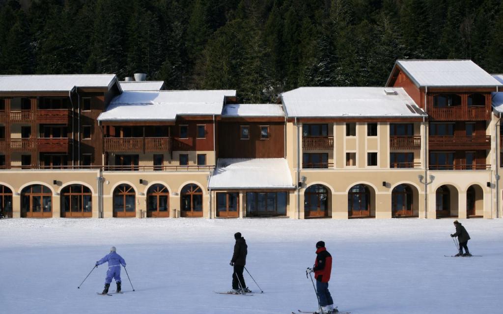 Slide Résidence Les Grandes Feignes à La Bresse au pied des pistes de la station en hiver sous la neige