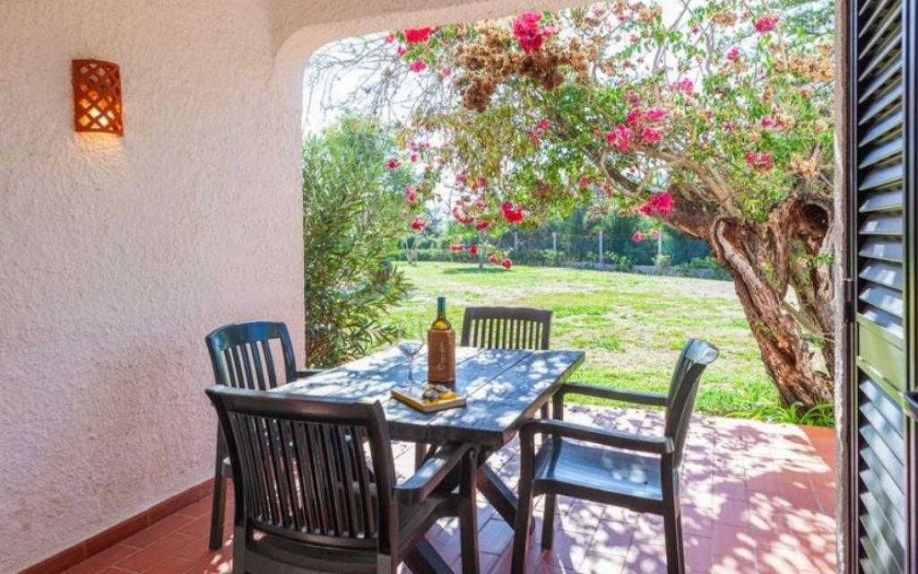 Slide Terrasse privative donnant sur les jardins de la résidence Pedras del Rei au Portugal avec salon de jardin
