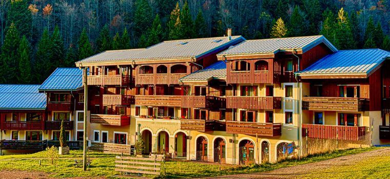 Vue globale de la Résidence Les Grandes Feignes au pieds des pistes en été lors du couché de soleil