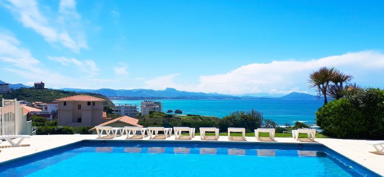 Vue globale des extérieurs de la résidence Eugénie à Biarritz avec piscine extérieure et court de tennis