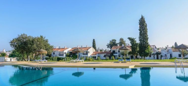 Piscine extérieure avec des transats et parasols au sein de la résidence Pedras da Rainha*** à Tavira au Portugal