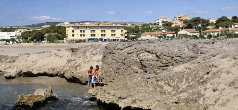 Vue globale de la résidence Neptune à Saint Pierre la mer avec la résidence en fond et la plage en premier plan