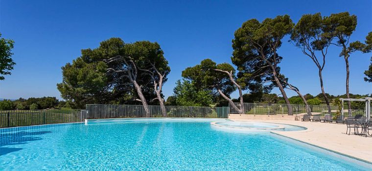 Outdoor swimming pool at the Provence Country Club residence with views of nature and a beautiful blue sky.