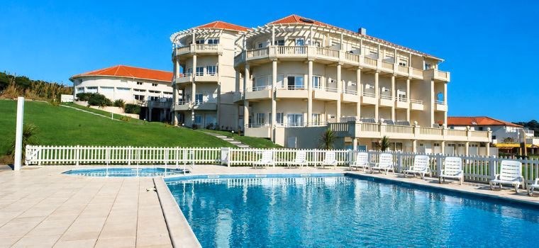 Vue globale des extérieurs de la résidence Eugénie à Biarritz avec piscine extérieure et court de tennis