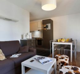 Séjour et cuisine d'un des logements à la résidence Au Coeur des Ours aux 2 Alpes
