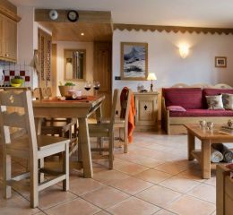 Inside a cosy apartment at Le Cœur d’Or residence in Bourg-Saint-Maurice, with living room, dining area and fully equipped kitchen