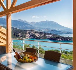 alcon avec table et panier de fruits à la résidence L’Écrin du Lac à Chorges, offrant une vue imprenable sur le lac de Serre-Ponçon et les montagnes