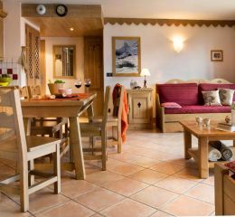 Intérieur d’un appartement chaleureux à la résidence Le Cœur d’Or à Bourg-Saint-Maurice, avec salon, coin repas et cuisine équipée